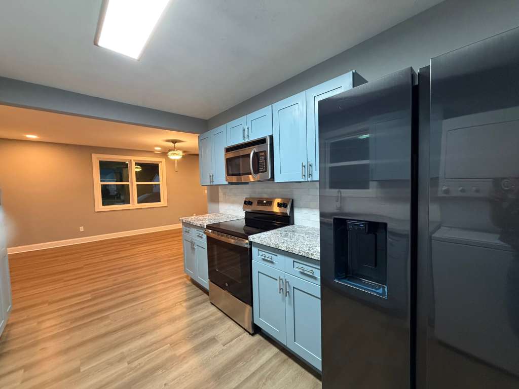 Completed kitchen with blue cabinets and new appliances