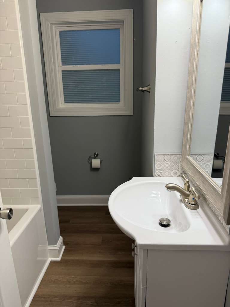 Completed bathroom tub and white tile surround
